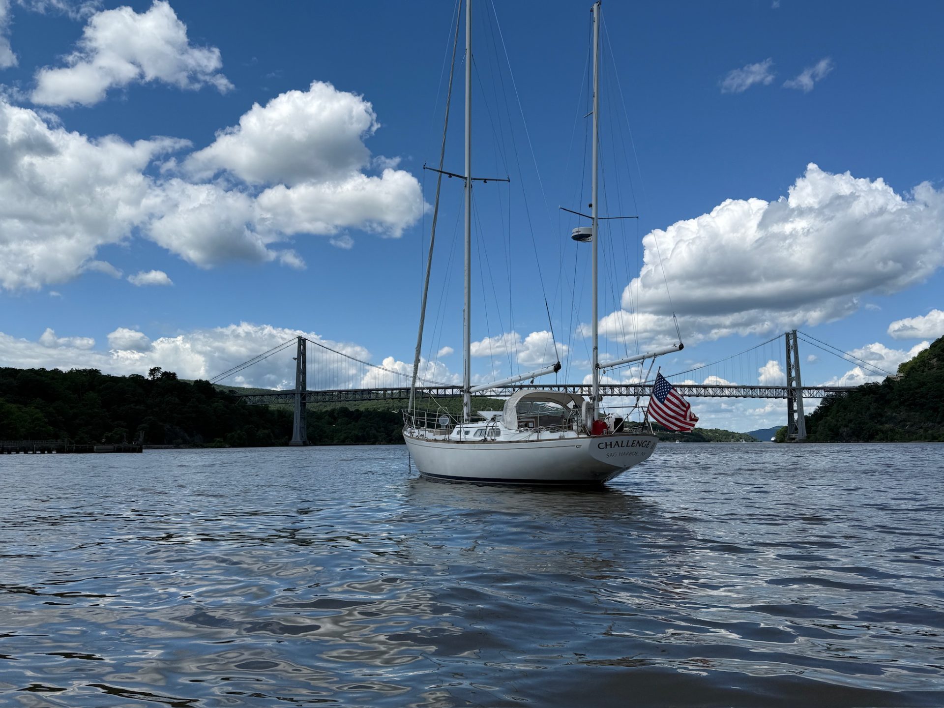 A sailing yacht at anchor below a bridge on the Hudson River